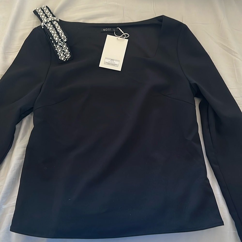 New with tags. Long sleeve SHEIN black top with sequin bow embellishment.